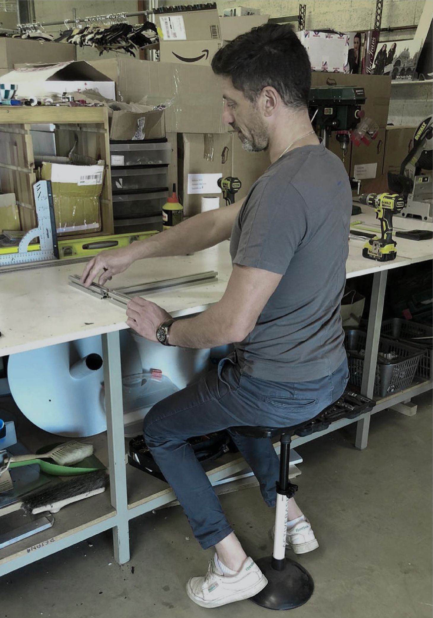 Un homme utilise le tabouret ergonomique ActiveBase pendant ses activités professionnelles au travail, sa posture est bonne.